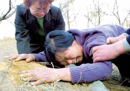 Nie Shubin bị tử hình năm 21 tuổi vì tội “hiếp dâm, giết người”. 10 năm sau (2005), thủ phạm thật của vụ án bị bắt và đã thú tội. Trong ảnh là mẹ Nie Shubin khóc ngất trên mộ con. Nguồn ảnh: China.org.cn