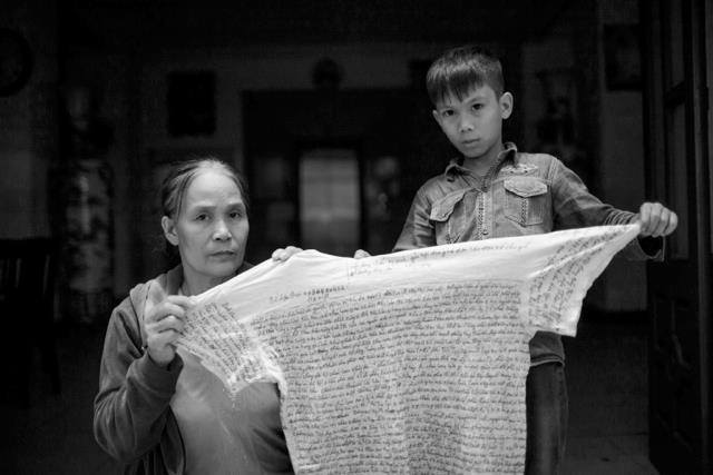 Mẹ và con trai tử tù Lê Văn Mạnh với chiếc áo in lá thư mà Lê Văn Mạnh gửi từ trong tù ra. Nguồn: Facebook Vụ án tử tù Lê Văn Mạnh.