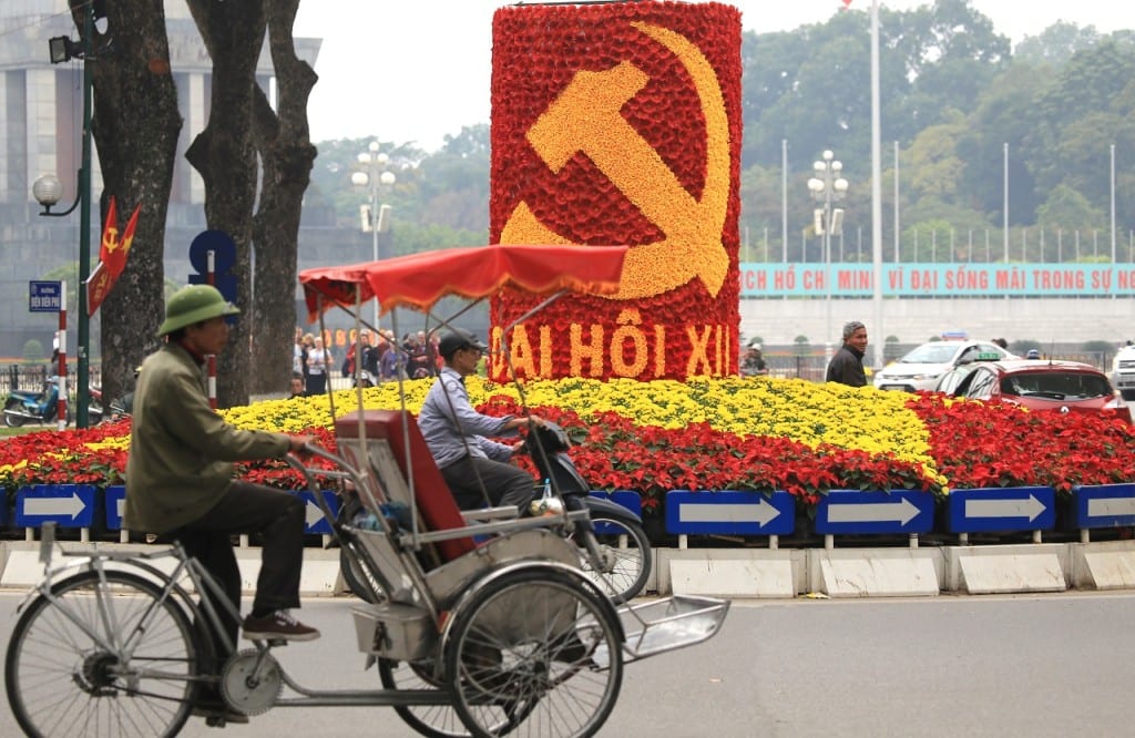 In this Tuesday, Jan. 19, 2016, photo, vehicles drive past a sign marking the 12th Congress of the Communist Party of Vietnam in Hanoi, Vietnam. This week, some 1,510 representatives of Vietnam's Communist party gather in the capital to pick the country's new leaders. (AP Photo/Hau Dinh)
