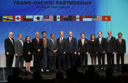 New Zealand Prime Minister John Key (6R) and Ministerial Representatives from 12 countries pose for a photo after signing the Trans-Pacific Partnership agreement in Auckland on February 3, 2016. / AFP / MICHAEL BRADLEY