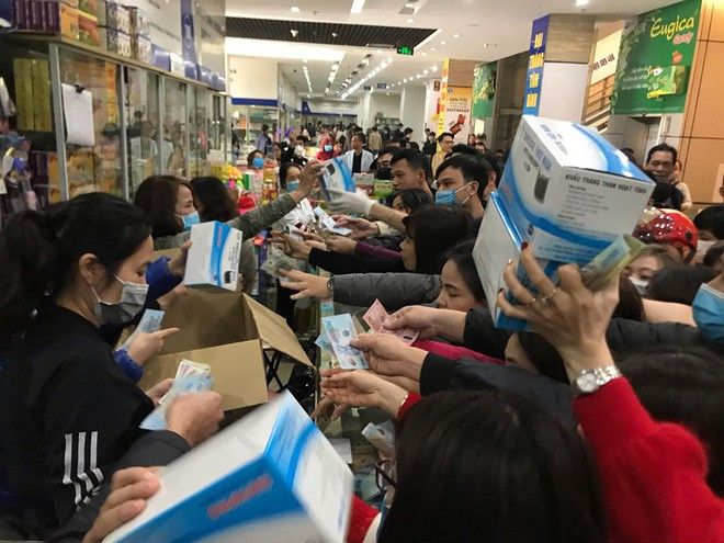 Người dân chen lấn mua khẩu trang y tế tại một hiệu thuốc. Ảnh: Báo Đầu tư.