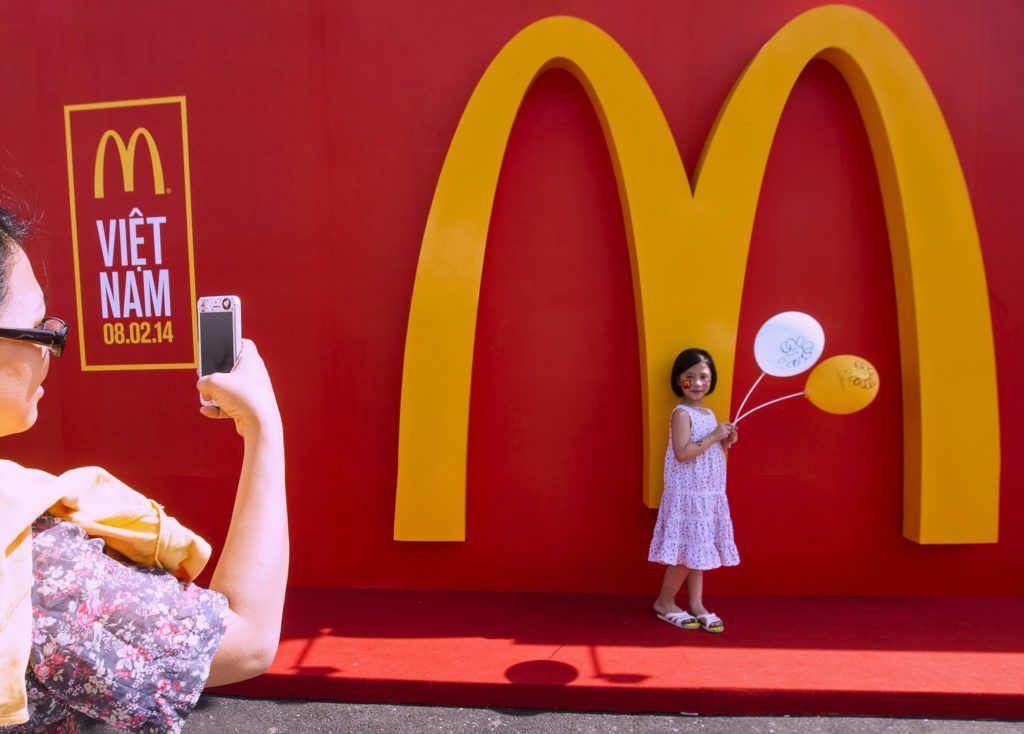 Các nhà tư bản phương Tây giờ đây được chào đón nhiệt liệt ở Việt Nam. Ảnh: Lễ khai trương chuỗi nhà hàng McDonald's ở TP. Hồ Chí Minh, ngày 8/2/2014 của Le Quang Nhat | AFP | Getty Images.