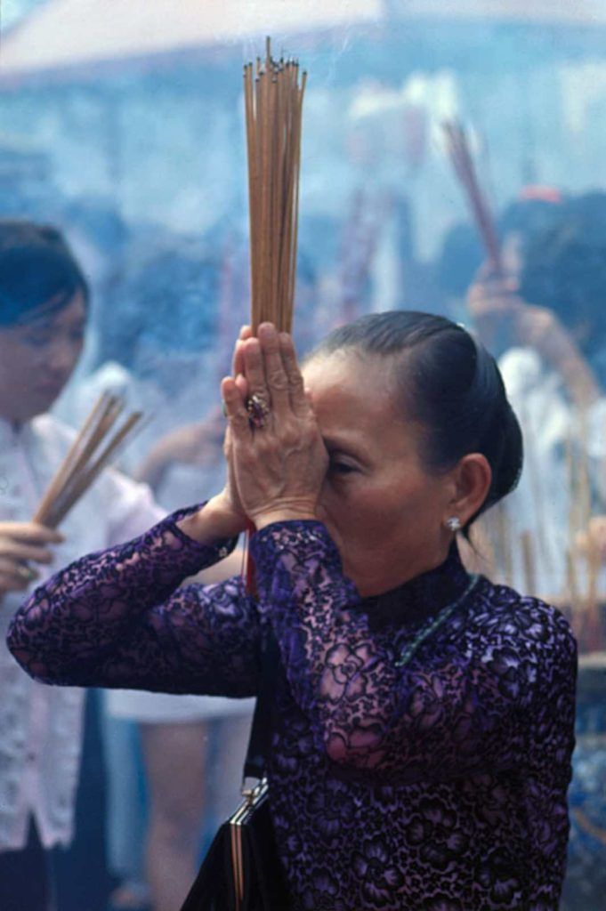 Một người phụ nữ thắp nhang trong một ngôi đền ở Chợ Lớn vào dịp Tế Nguyên Đán năm 1962, ảnh chụp vào ngày 6/2/1970. Ảnh: Bettmann/CORBIS.