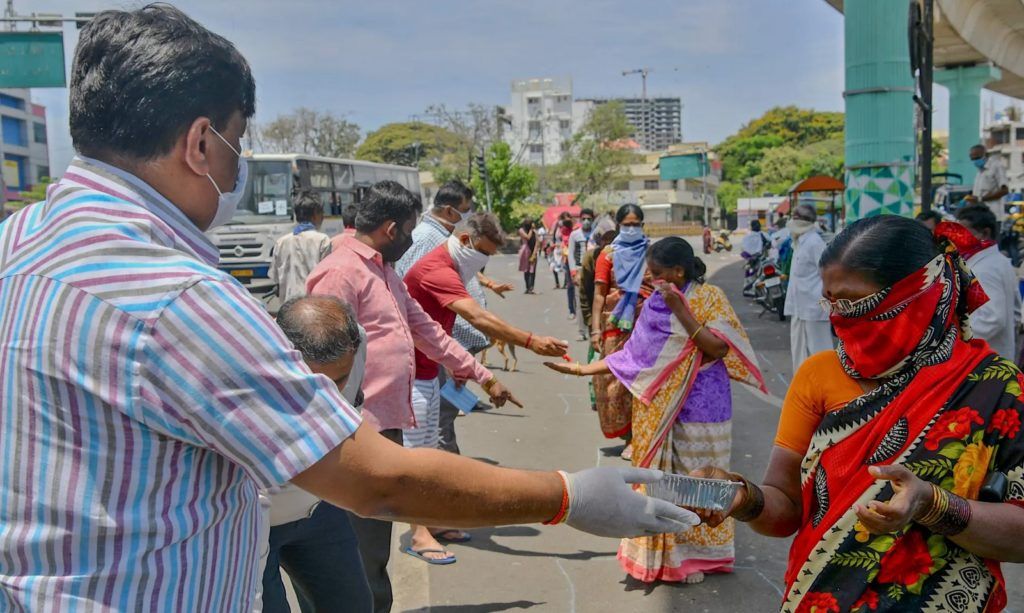Người dân phân phát đồ ăn miễn phí ở Bangalore, Ấn Độ. Ảnh:  Manjunath Kiran/AFP via Getty Images.
