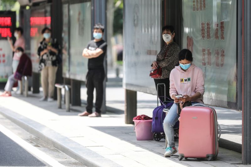 Hành khách tại một trạm xe bus ở Vũ Hán, Trung Quốc, ngày 11/5/2020. Ảnh: AFP.