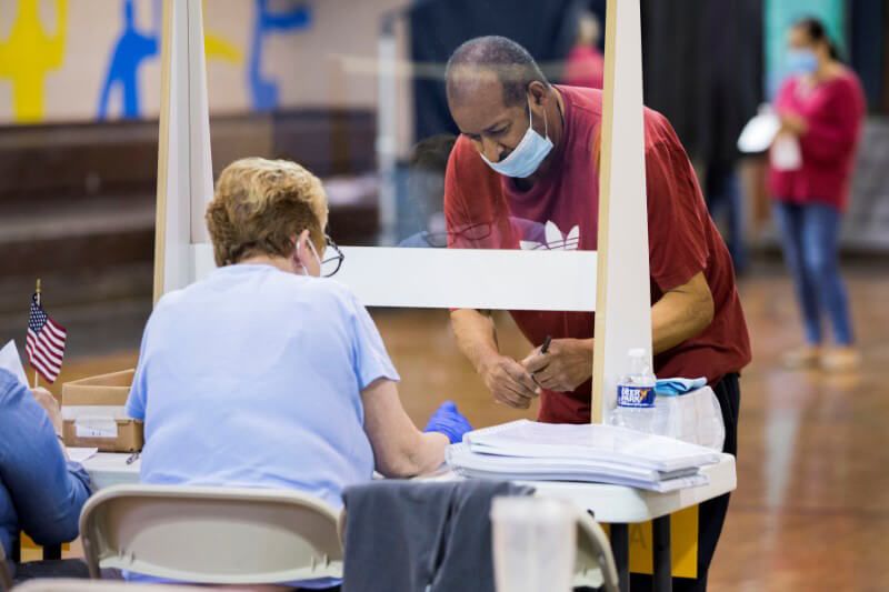 Nhân viên bầu cử (ngồi) hướng dẫn cử tri đi bầu ở Philadelphia năm 2020. Ảnh: Reuters.
