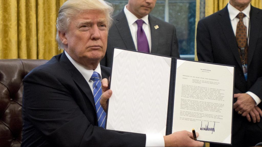 TT Trump cầm lệnh hành pháp ra lệnh cho Mỹ rút khỏi TPP tại Phòng Bầu Dục ở Nhà Trắng hôm 23/1/2017. Ảnh: UPI/Kyodo.